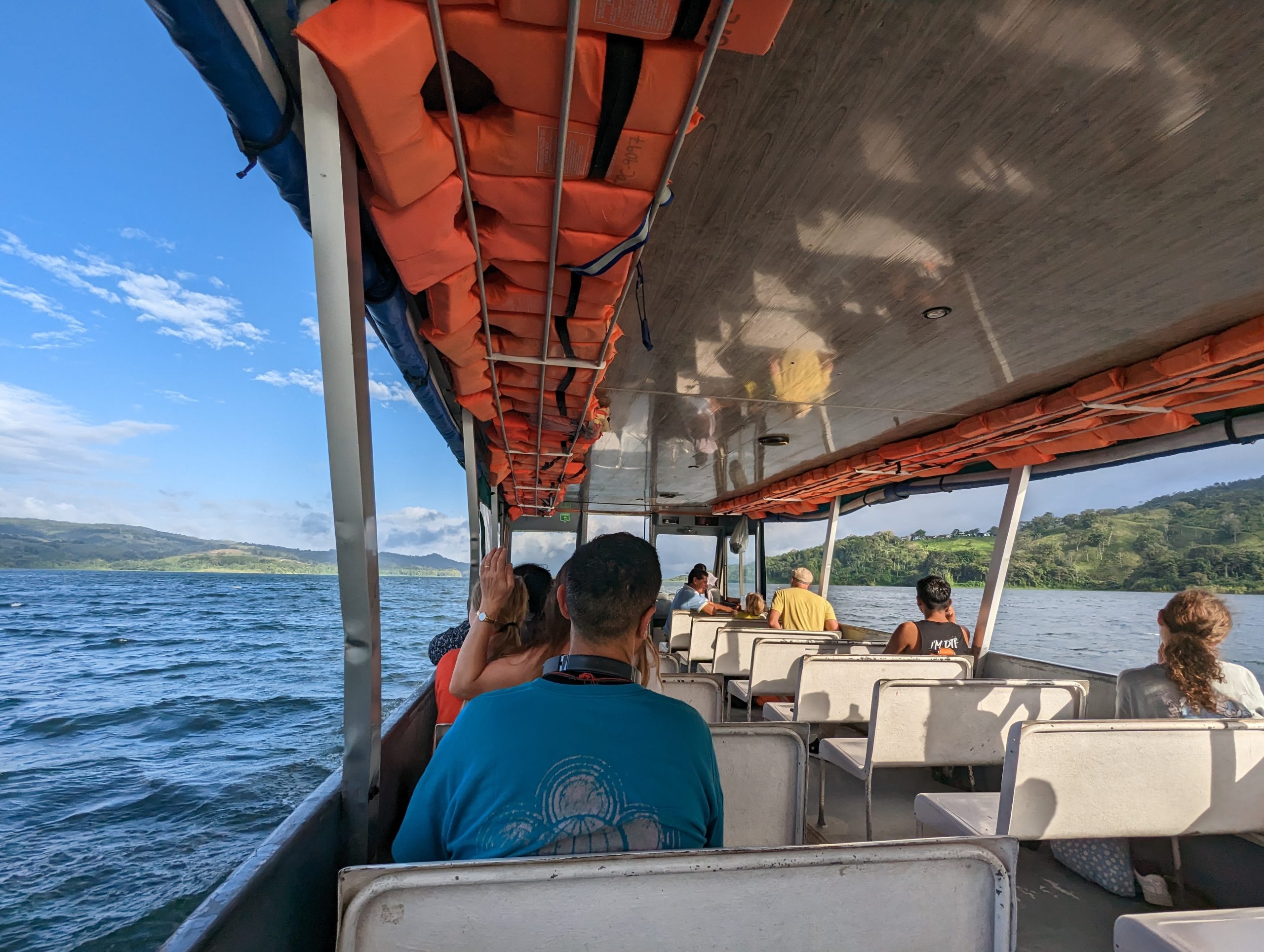 Passagiere auf einem Boot in Costa Rica, unterwegs auf einem Roadtrip ohne Auto.