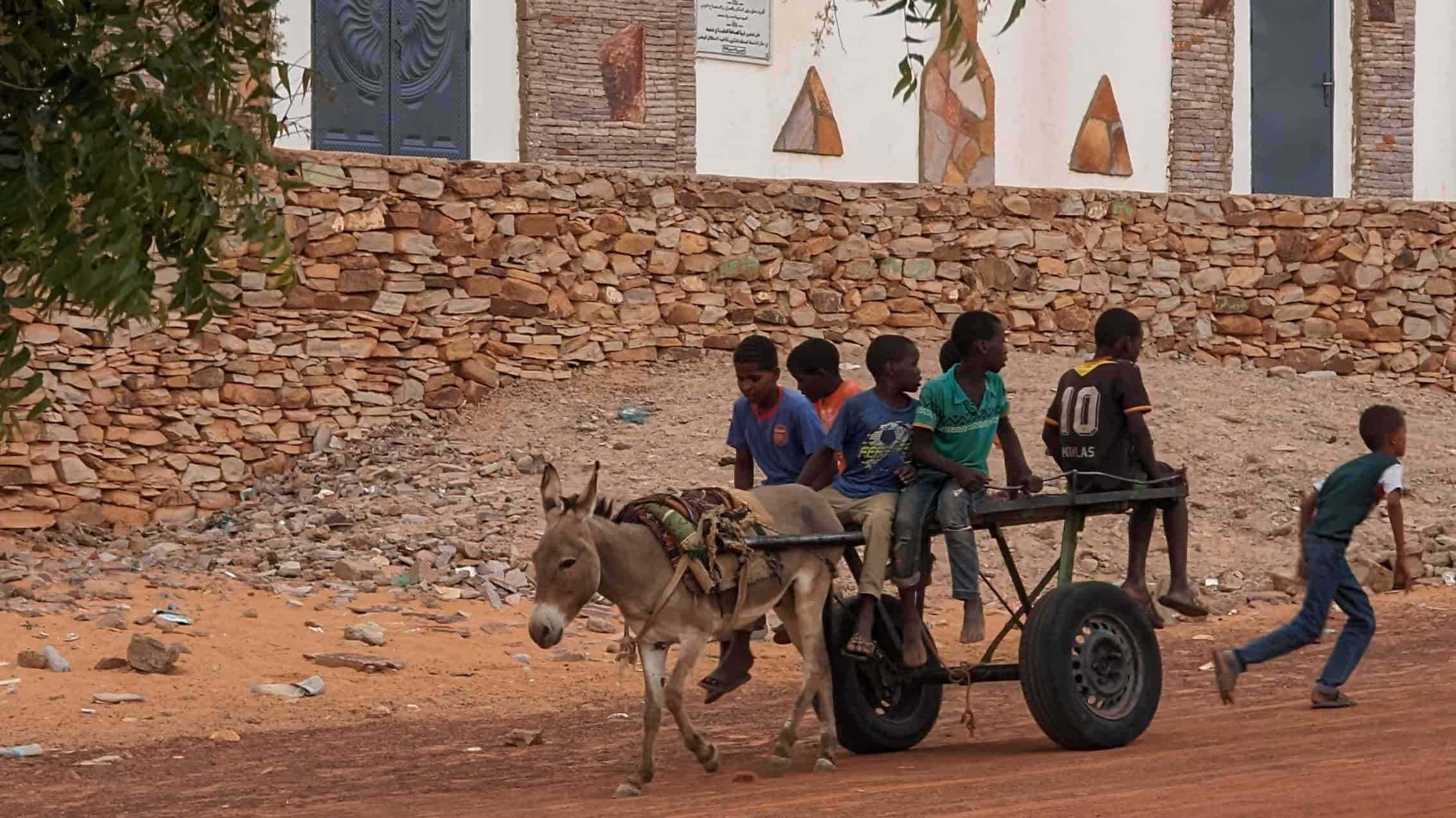 Kinder ziehen einen Esel-Karawanenwagen in der Wüstenstadt Chinguetti.
