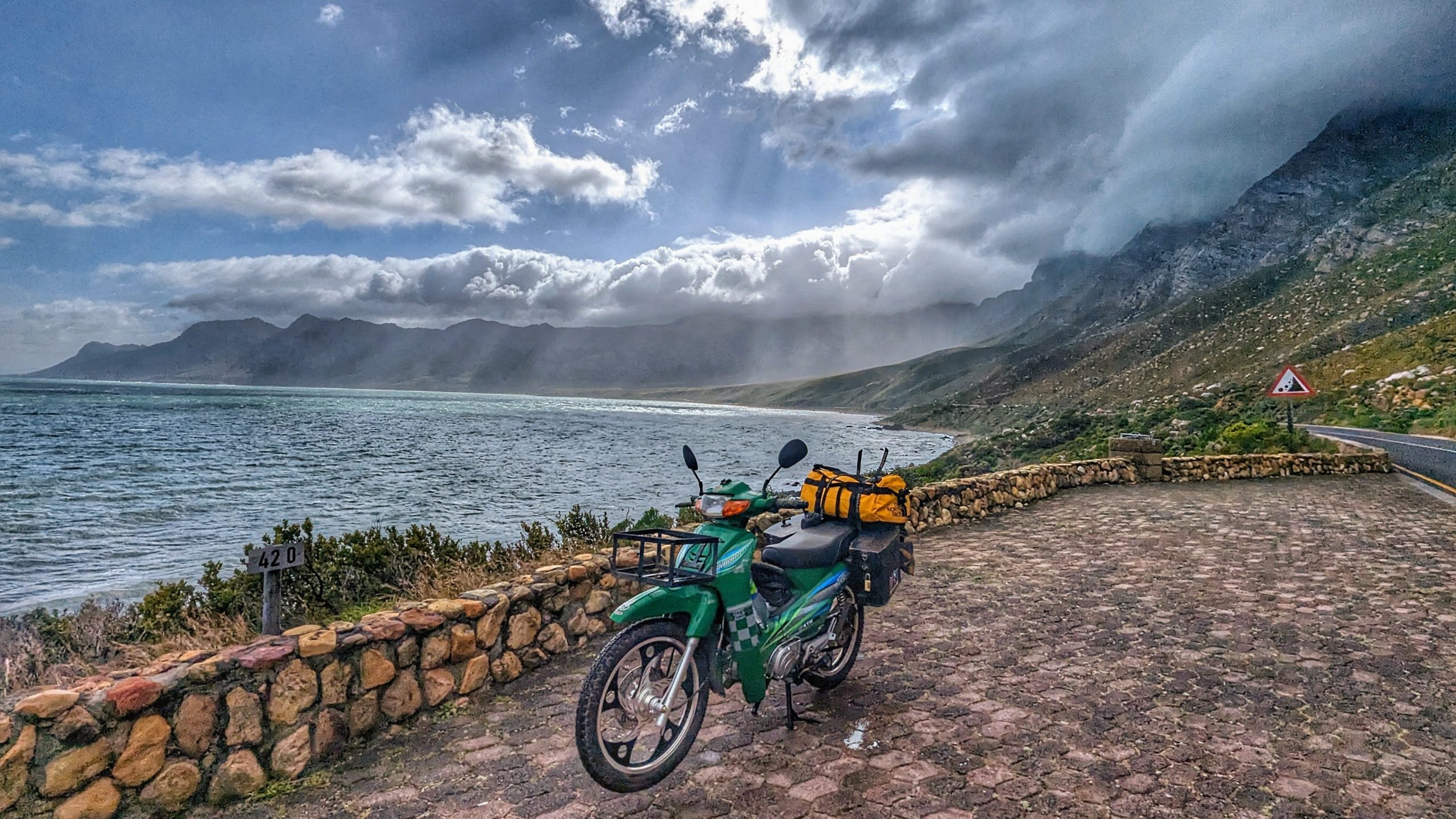 Motorrad auf der malerischen Garden Route in Südafrika, umgeben von Bergen und Meer, ideal für Roadt.
