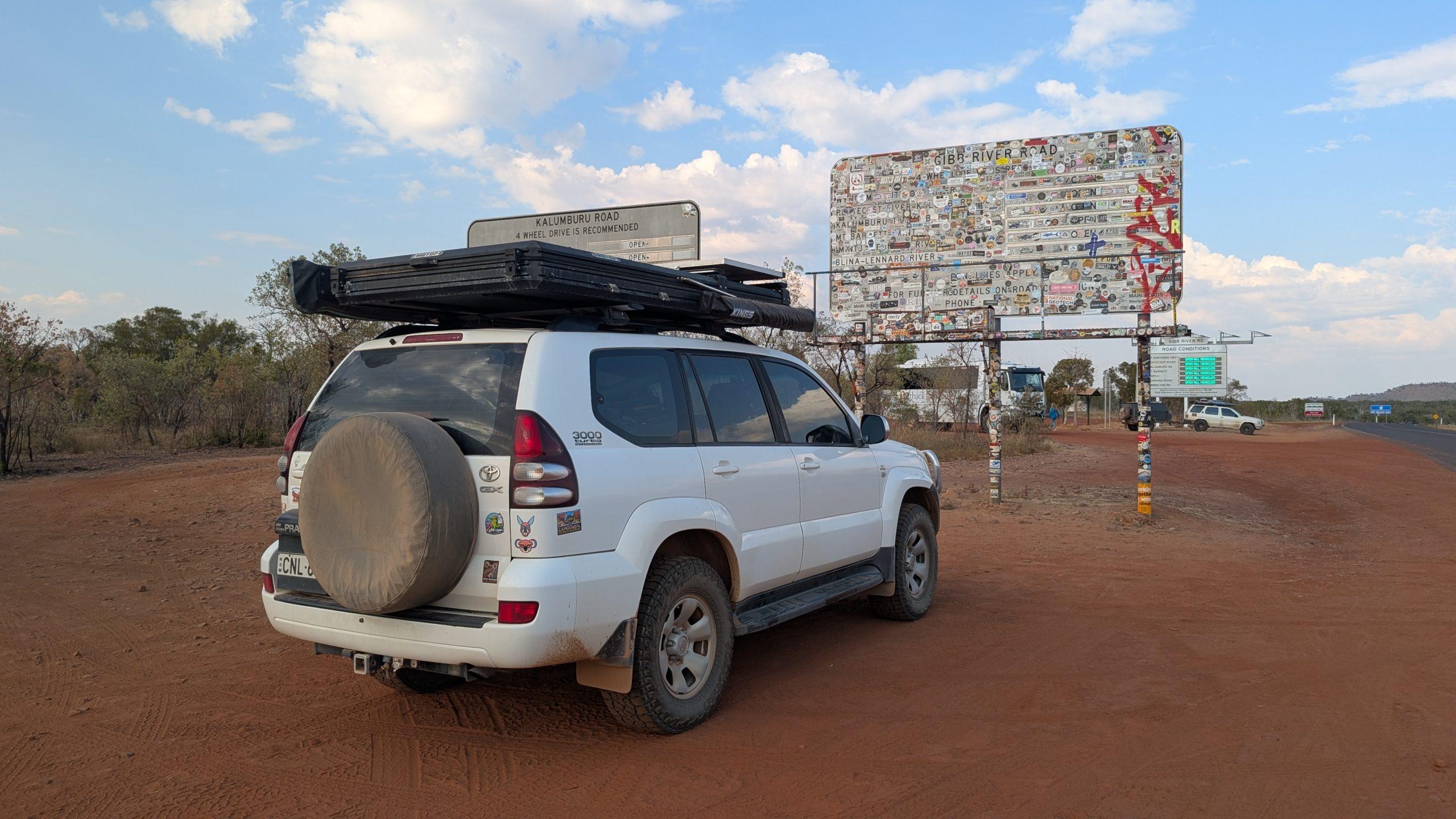 Auto auf afrikanischer Straße mit Reiseausrüstung und Dachbox.