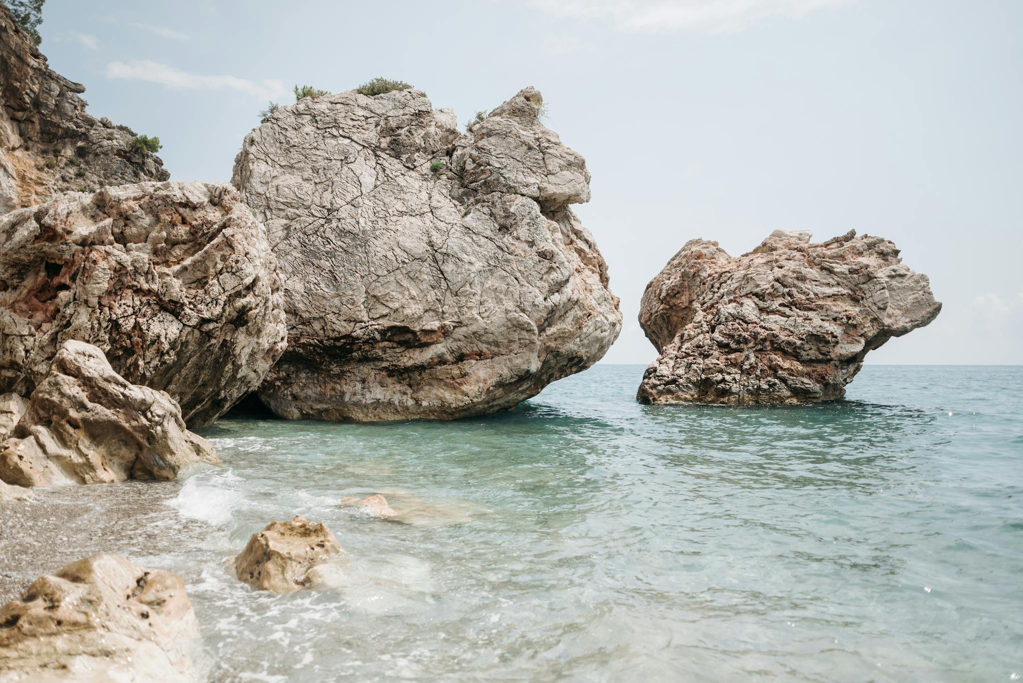 Stunning rock formations by the tranquil seashore, perfect for a summer escape.